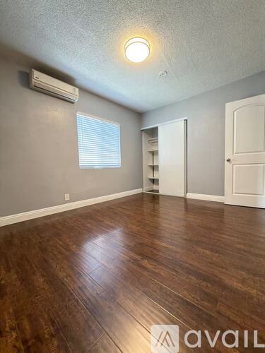 A room with wooden flooring and a white door.