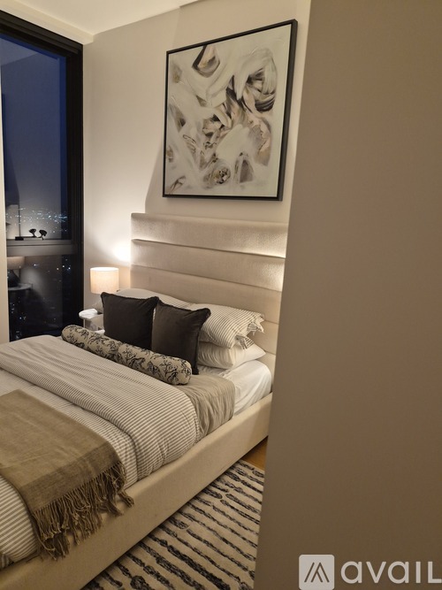 A bedroom with a large bed and a framed picture on the wall.