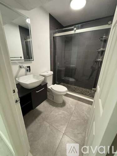 A bathroom with a sink, toilet, and shower.