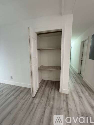 A room with a white door and shelves inside.
