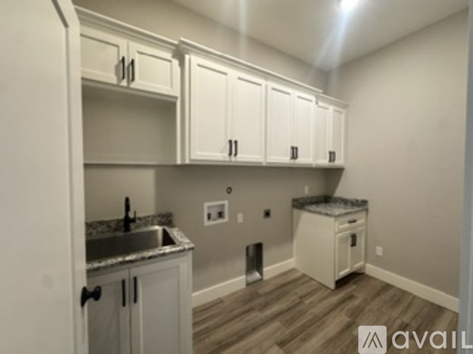 A kitchen with white cabinets and a granite countertop.