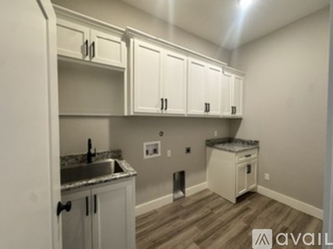 A kitchen with white cabinets and a granite countertop.