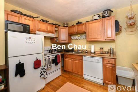 A kitchen with wooden cabinets and a white fridge.