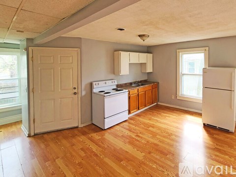 A kitchen with wooden floors and white appliances.