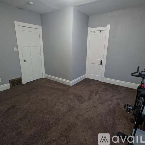 A room with two white doors and a carpeted floor.