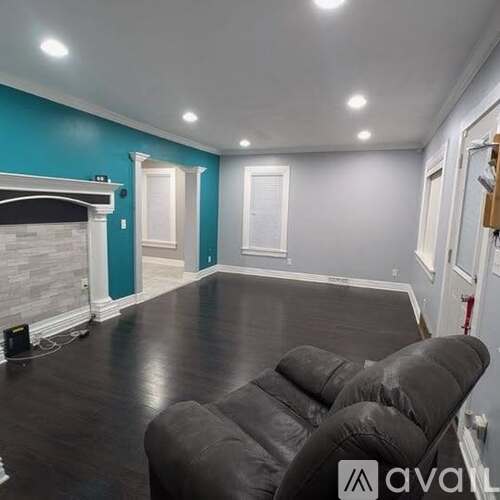 A living room with a fireplace and a grey couch.