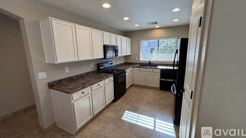 A kitchen with white cabinets and a granite countertop.