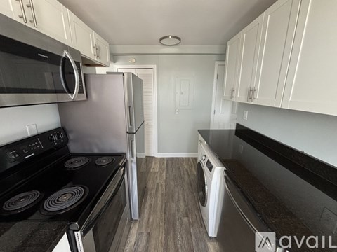 A kitchen with a black stove and white cabinets.