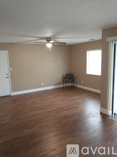 A room with wooden floors and a ceiling fan.