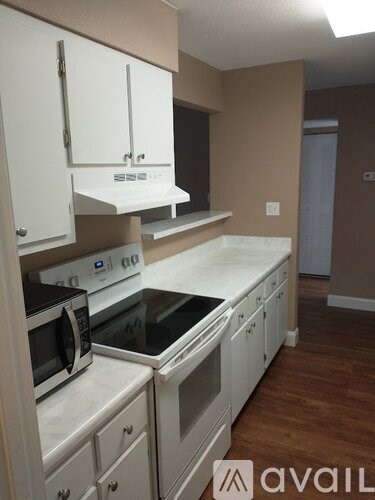 A kitchen with white cabinets and appliances.