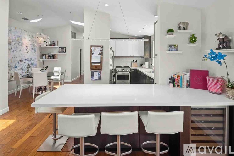 A modern kitchen with a white table and chairs.