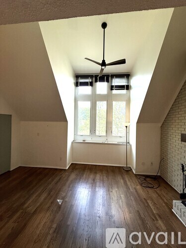 A room with a ceiling fan and a window with blinds.