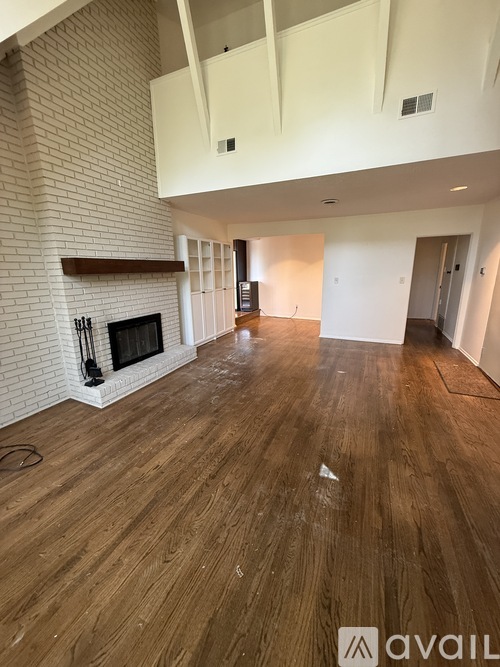 A room with wooden floors and a fireplace.