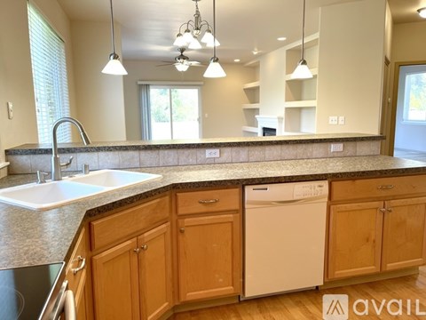 A kitchen with wooden cabinets and a white dishwasher.