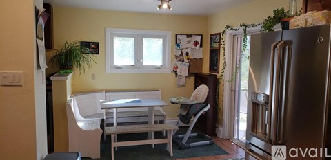 A kitchen with a table and chairs and a fridge.