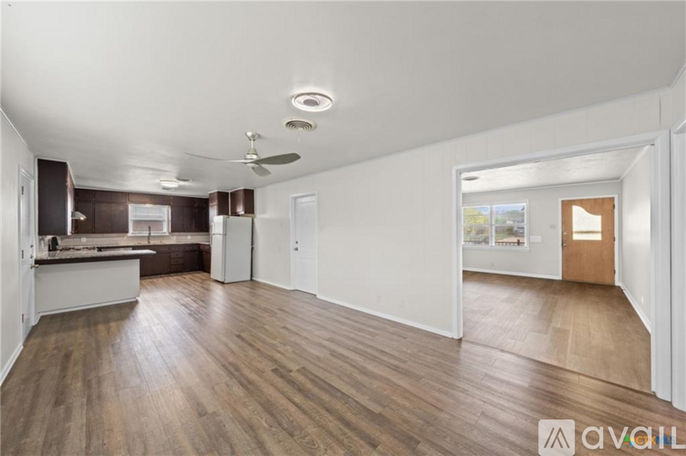 A spacious room with wooden flooring and a ceiling fan.