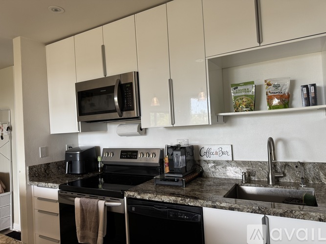 A kitchen with a black stove top oven and a black microwave.