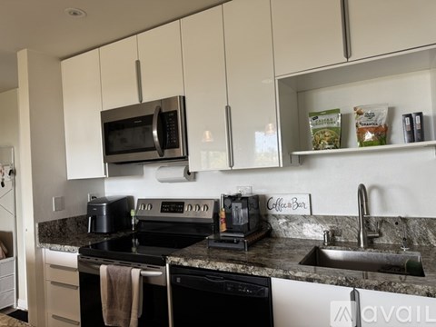 A kitchen with a black stove top oven and a black microwave.