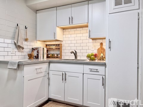 A kitchen with white cabinets and a white refrigerator.
