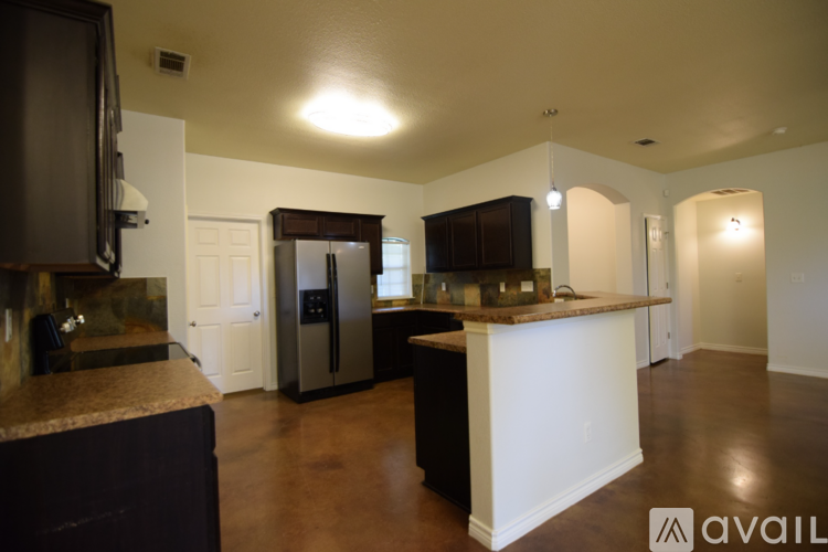 A kitchen with a black refrigerator and a white island.