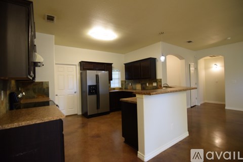 A kitchen with a black refrigerator and a white island.