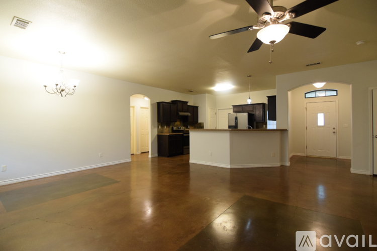 A spacious room with a ceiling fan and a chandelier.