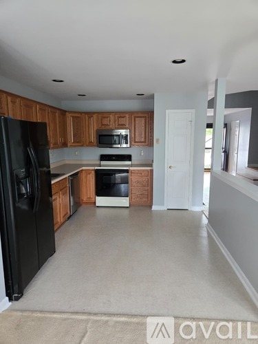 A kitchen with black appliances and wooden cabinets.