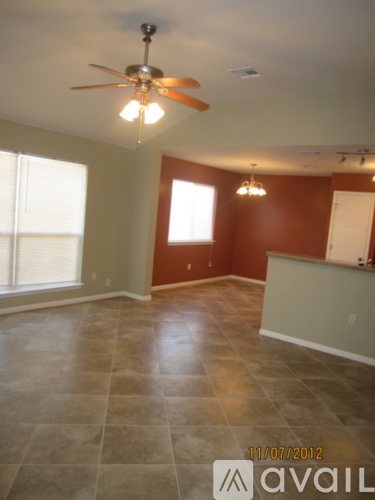 A room with a ceiling fan and tile flooring.