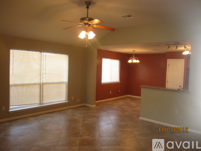 A room with a ceiling fan and a window with blinds.