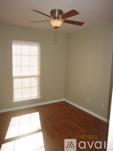 A room with a ceiling fan and a window.