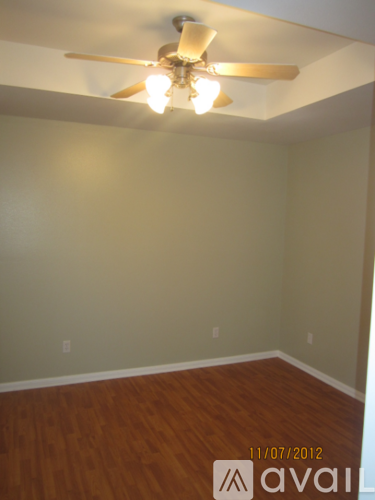 A room with a ceiling fan and wooden floors.
