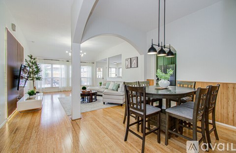 A modern dining room with a wooden table and chairs.