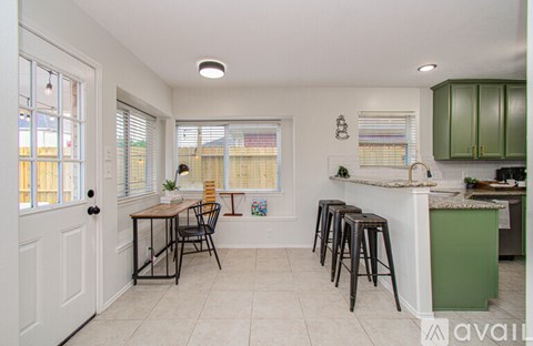 A kitchen with a table and chairs in the middle of the room.
