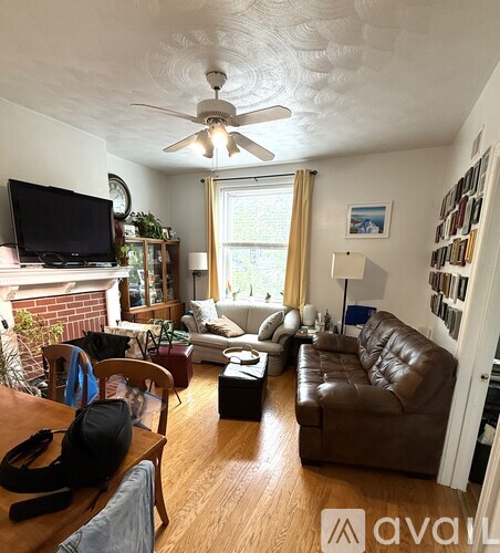 A living room with a brown leather couch and a television.