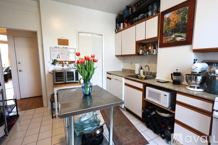 A kitchen with a table and a vase of flowers on it.