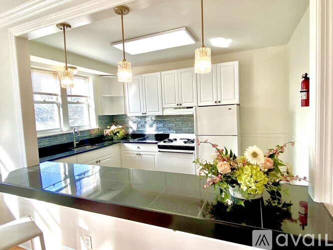 A kitchen with a granite countertop and white cabinets.