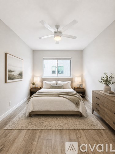 A bedroom with a bed, nightstands, and a ceiling fan.