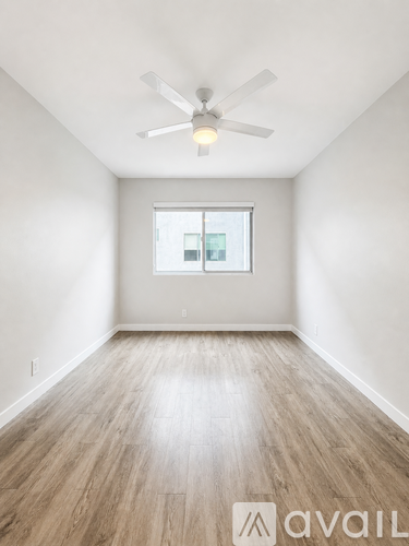 A room with a ceiling fan and a window.