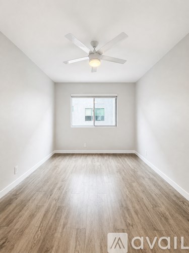 A room with a ceiling fan and a window.