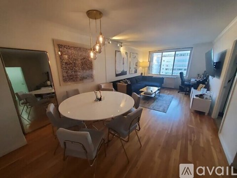 A living room with a white table and chairs, a couch, and a television.