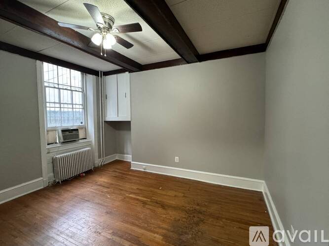 A room with wooden floors and a ceiling fan.
