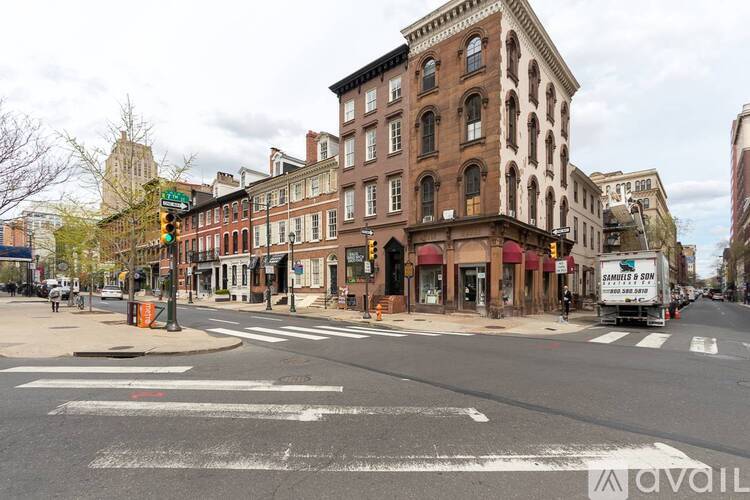 A street view of a city with buildings, a crosswalk, and a truck.