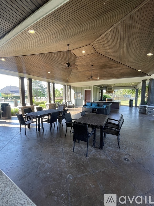 A large room with a wooden ceiling and a long table with chairs.