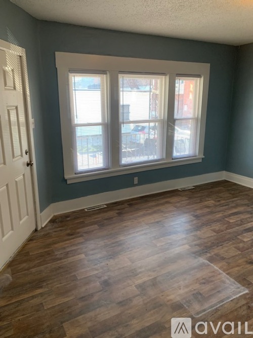 A room with a wooden floor and a window.