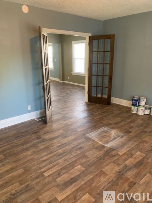 A room with wooden flooring and a ladder against the wall.