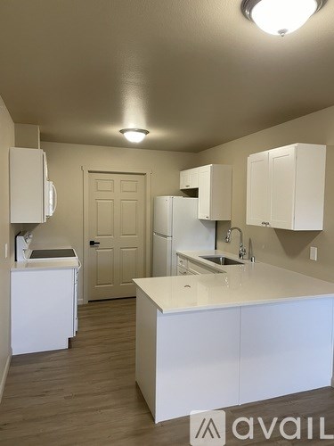 A kitchen with white cabinets and a white counter top.