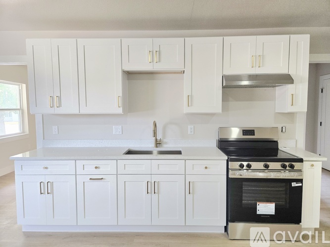 A kitchen with white cabinets and a black oven.