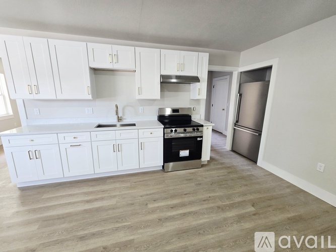 A kitchen with white cabinets and a black stove top oven.