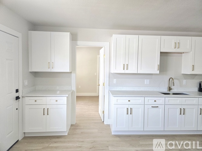 A kitchen with white cabinets and a sink.
