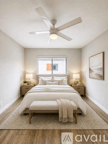 A bedroom with a bed, two lamps, and a ceiling fan.